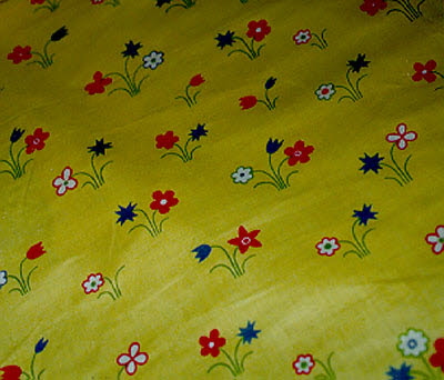 Rouleau de toile à fleurs stylisées sur fond jaune