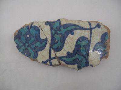 Fragment de carreau aux feuilles bifides et fleurons turquoise meublés de rumis bleu cobalt