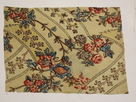 Fragment fond crème, décor de branches avec des fleurs et feuilles bleues, rouges et roses