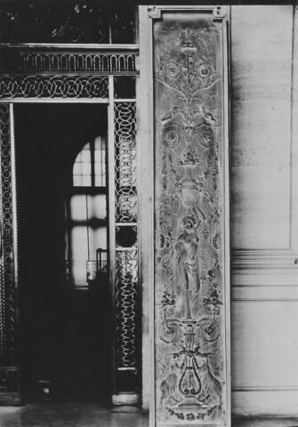 Panneau décoratif à motifs de candélabres orné d'une femme portant un vase avec rinceaux