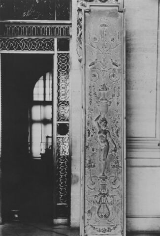 Panneau décoratif à motifs de candélabres orné d'une femme portant un vase avec rinceaux