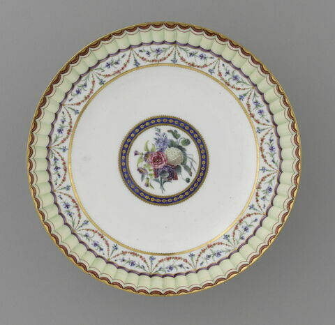 Assiette, d'une paire (R 758) 
Au fond, un bouquet de fleurs, entouré d'un cercle bleu ponctué d'or. Au marli, guirlande de soses et de bleuets suspendue à un lerge ruban jaune bordé de rouge et or., image 5/8