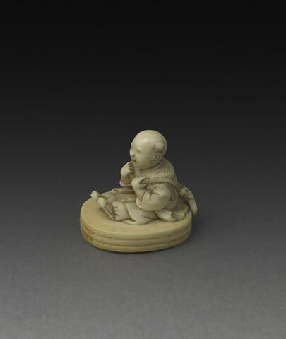 Netsuke : enfant assis (karako) sur un tambour percé