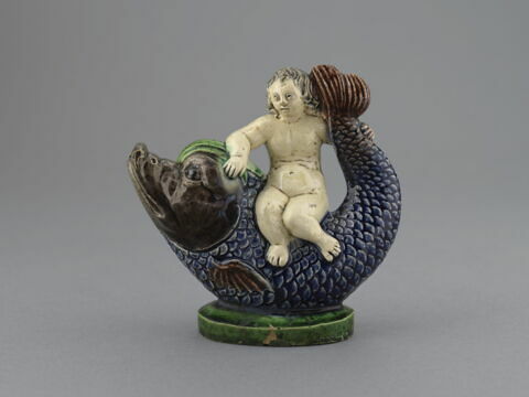 Vase à verser en forme de statuette : enfant nu chevauchant en amazone un dauphin