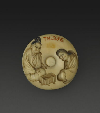 Manju netsuke avec deux personnages devant une caissette