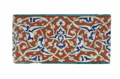 Carreau de frise aux fleurons bifides rumi sur fond rouge et liserés turquoise