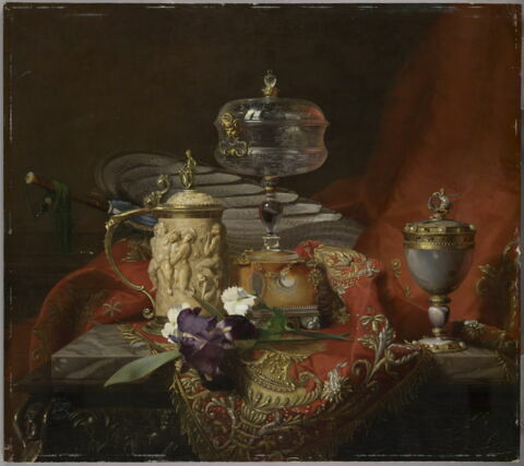 Nature morte aux objets d’art du Louvre : gemmes de Louis XIV et chope au triomphe de Silène sur une étoffe rouge brodée.